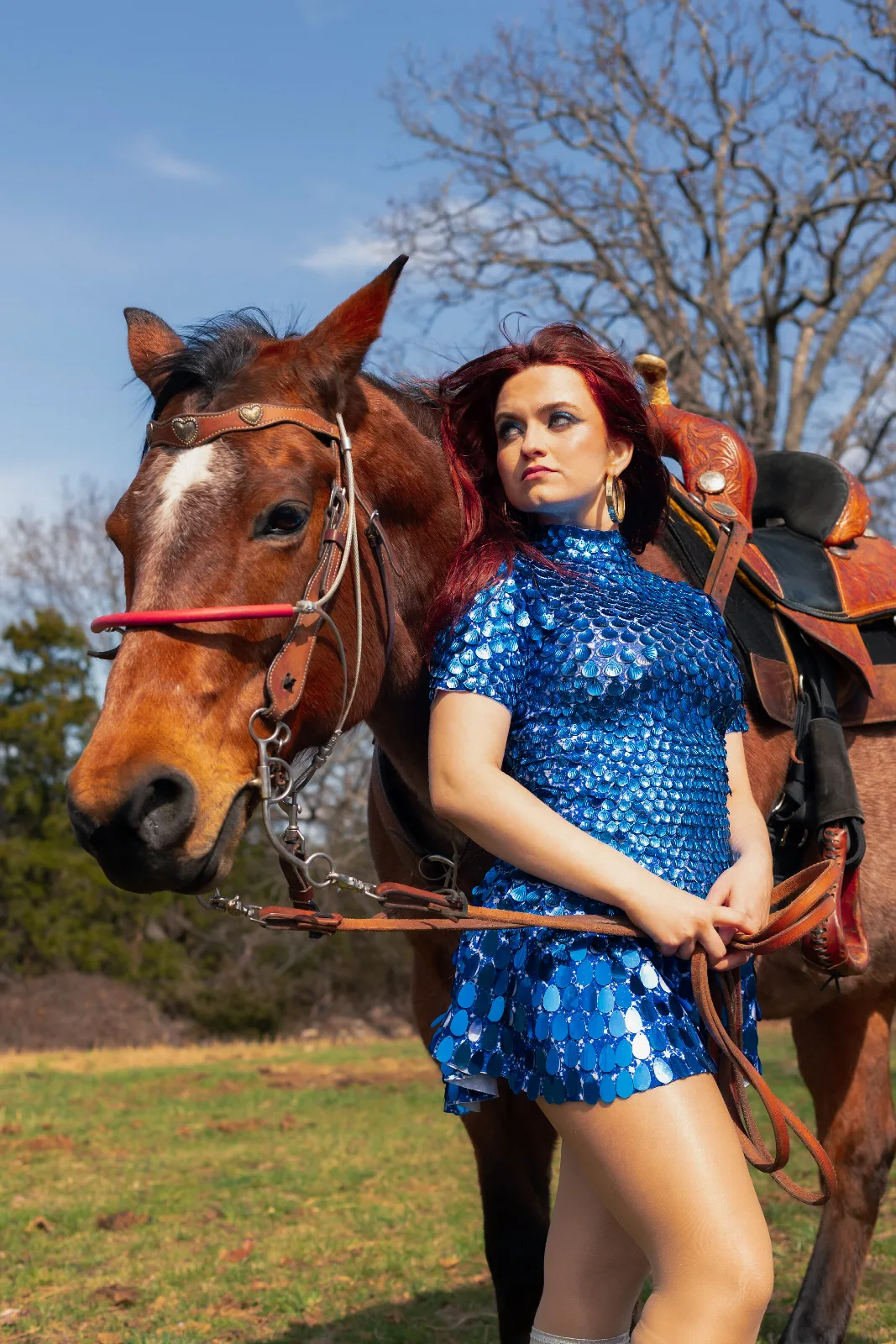 Scarlet O'Hara in a blue sequin dress beside a horse